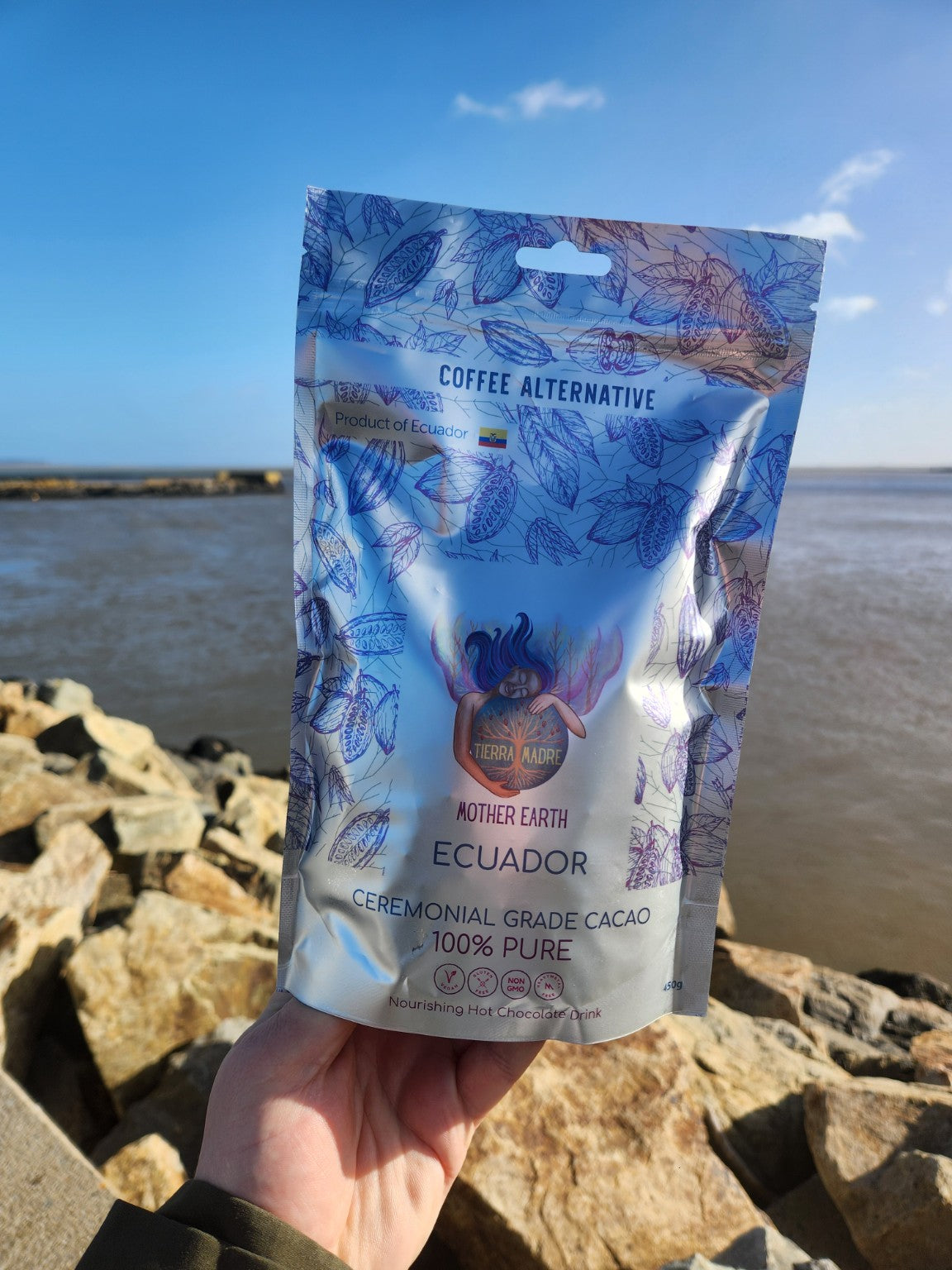 Mother Earth Ecuador cacao 450g pouch held beside the harbour.