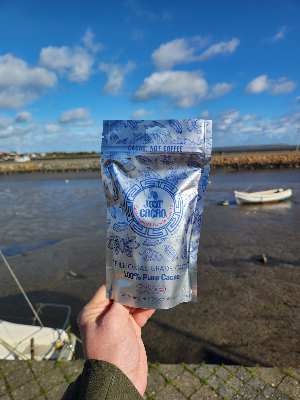 Just Cacao Venezuelan cacao pouch with boats and blue sky beside the harbour.