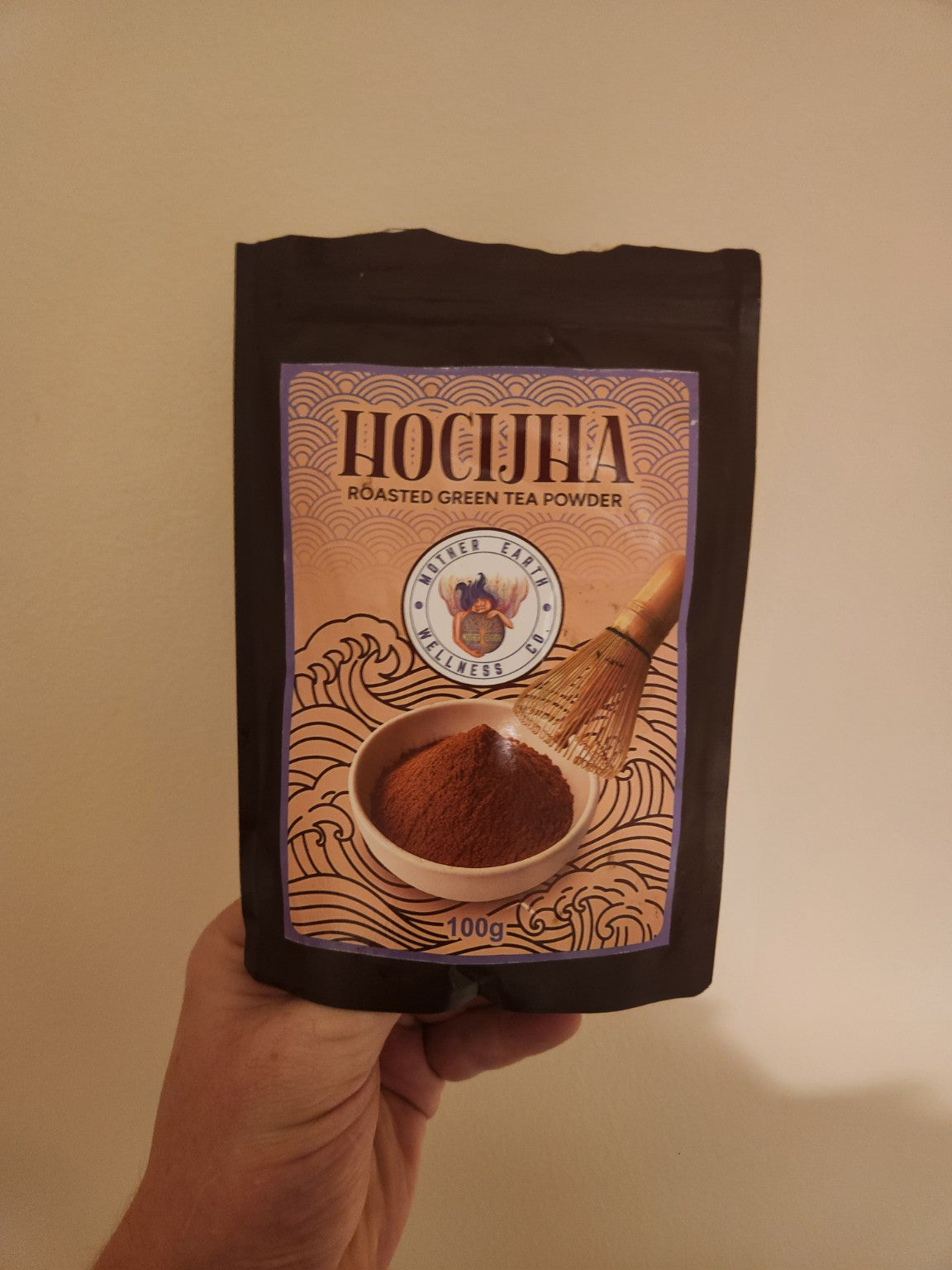 Mother Earth Hojicha roasted green tea powder 100g pouch photographed in hand